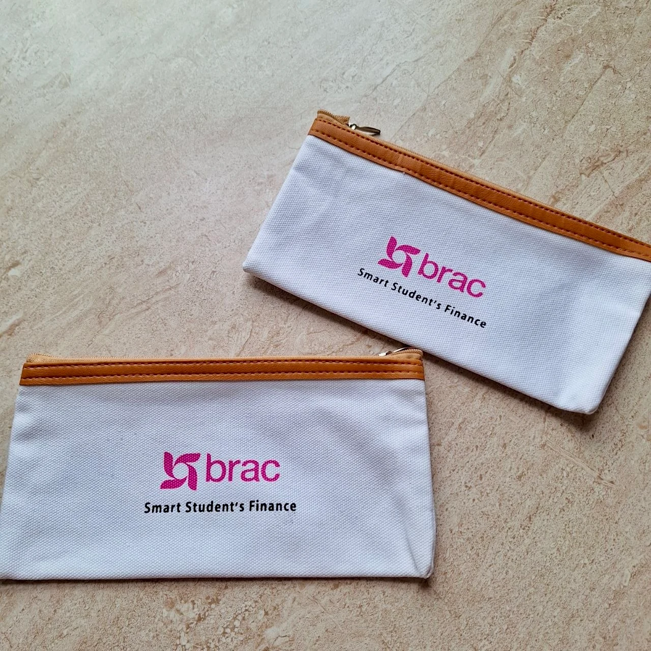 White zip pouches with BRAC Smart Student’s Finance printing