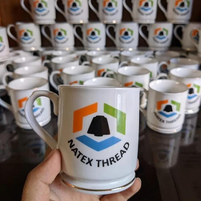 Custom printed ceramic mug with Natex Thread corporate logo and gold rim